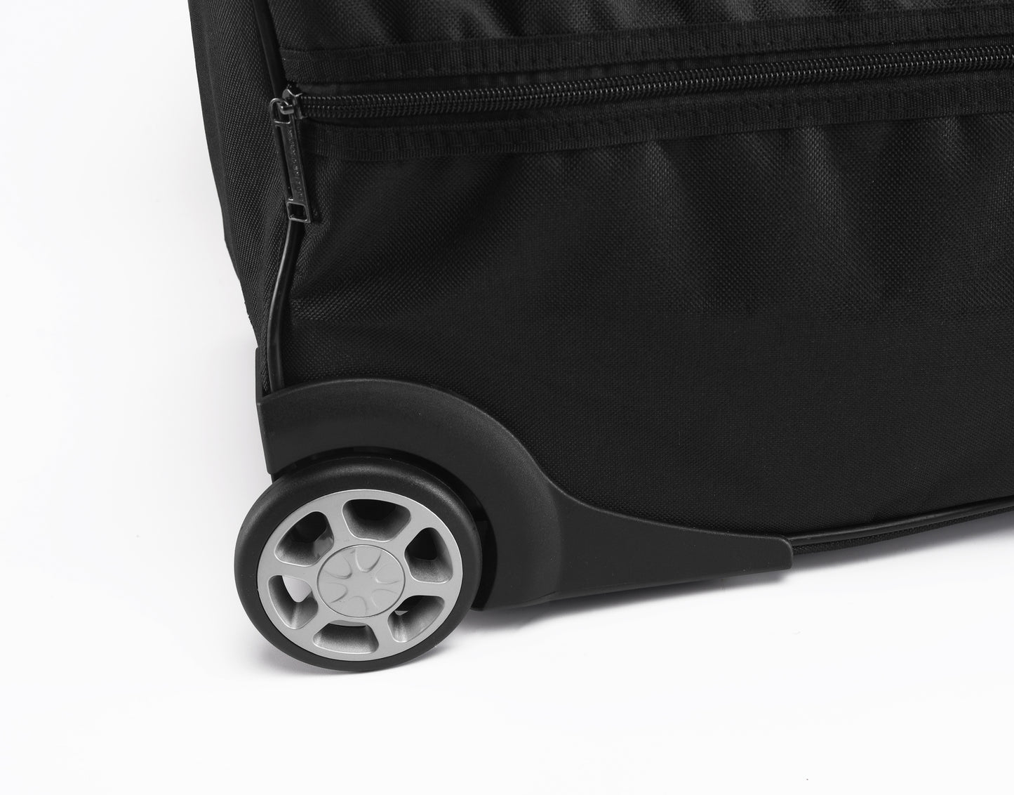 Close-up of a black suitcase wheel on a white background