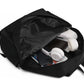 Black backpack with items like a phone and headphones inside on a white background