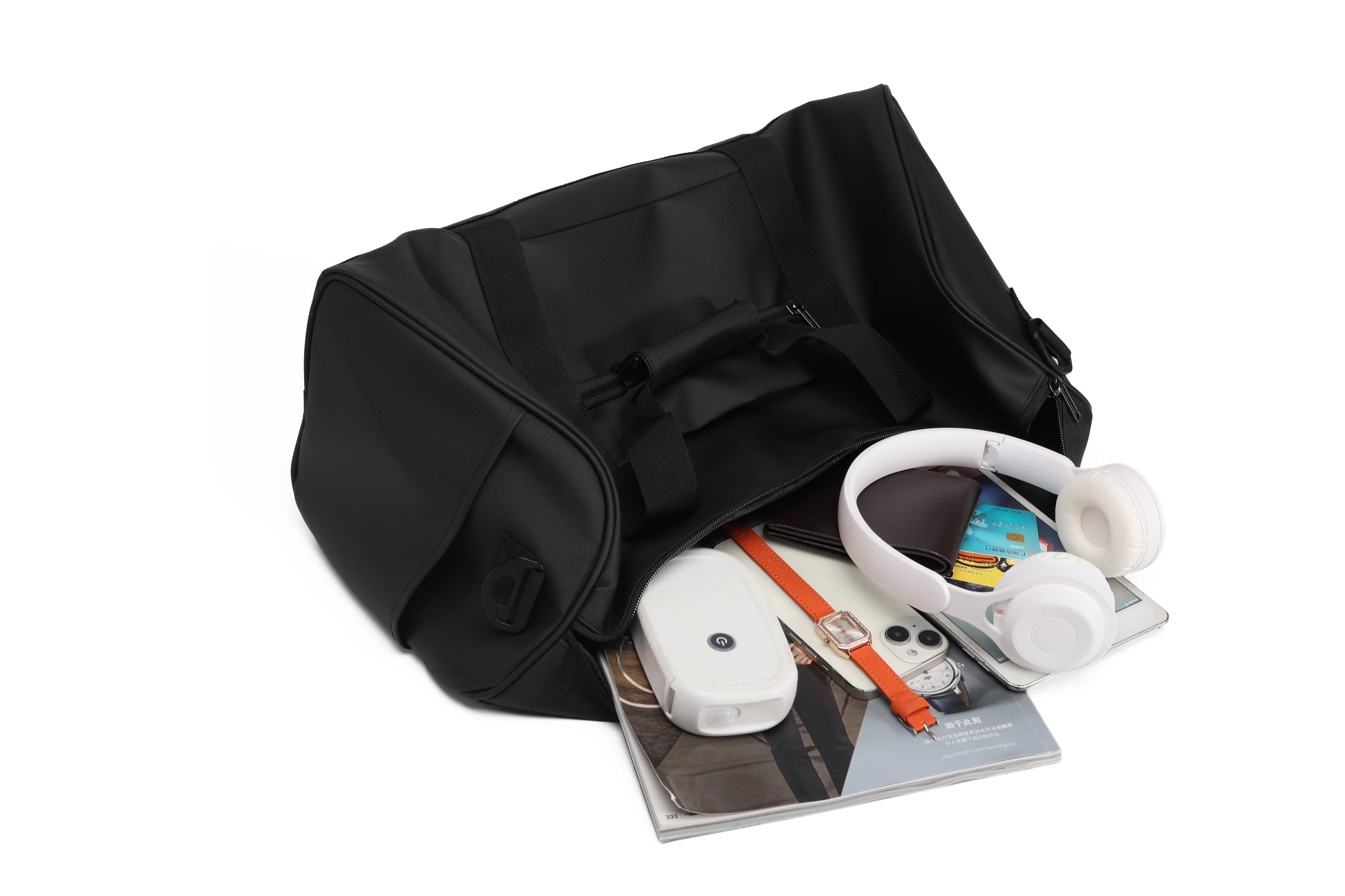 Black duffel bag with electronic devices and books on a white background