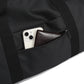 Black duffel bag with a phone and wallet inside on a white background