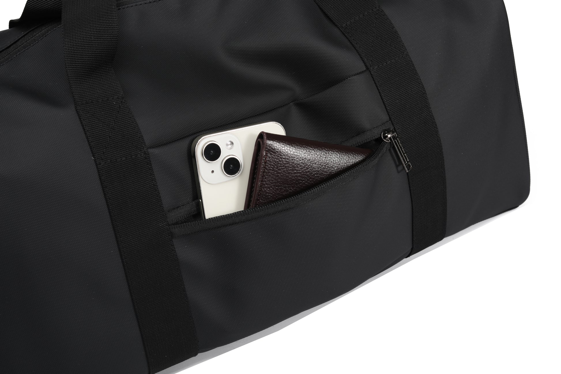 Black duffel bag with a phone and wallet inside on a white background